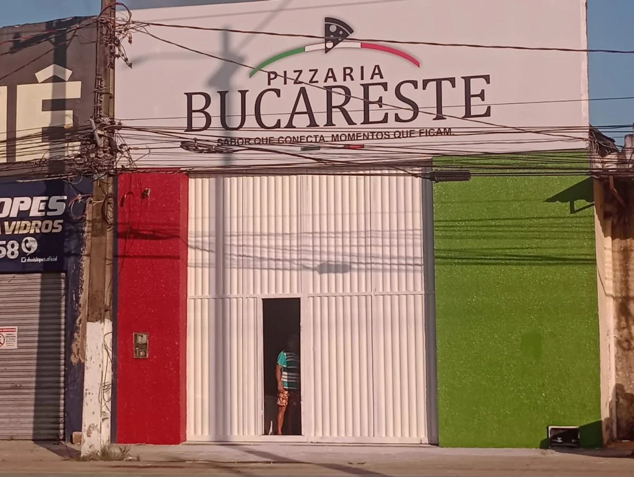 Fachada real da Pizzaria Bucareste com identificação permanente