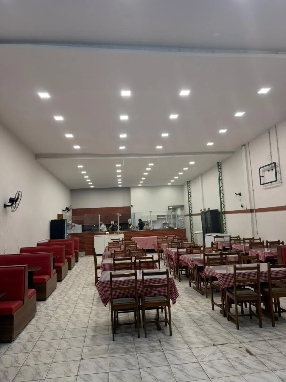 Salão real da Pizzaria Bucareste, com mesas e assentos